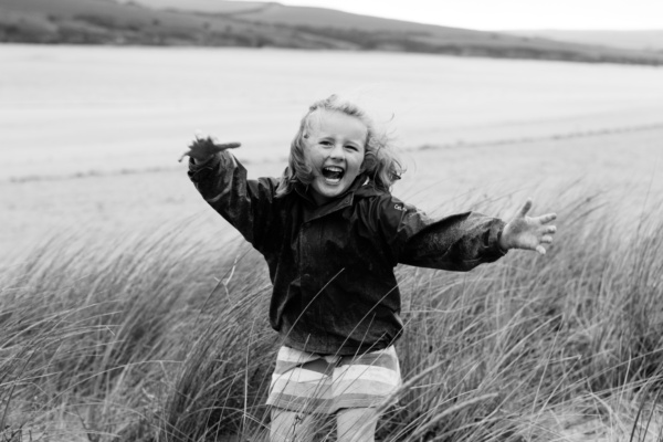 Girl plays in sand dunes.