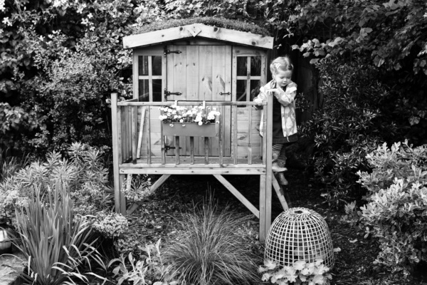 A girl plays in a treehouse.