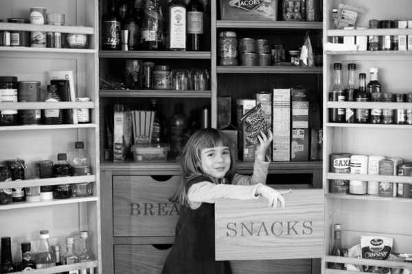 A girl raids a snack drawer.