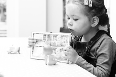 A girl reads a book to her doll.