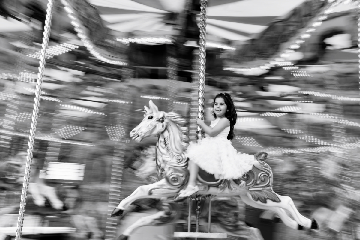 A girl rides a merry-go-round horse.