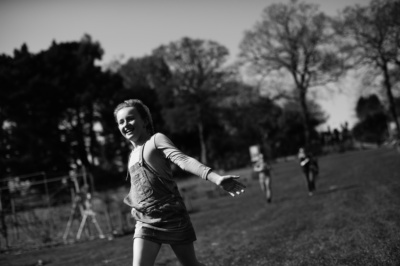 A girl runs across grass of a playground.