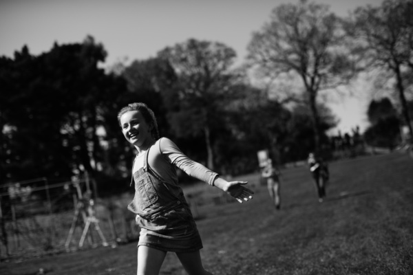 A girl runs across grass of a playground.