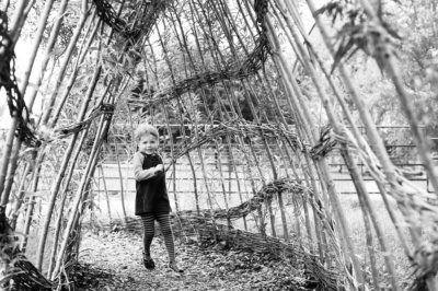 A girl runs through a rustic archway.