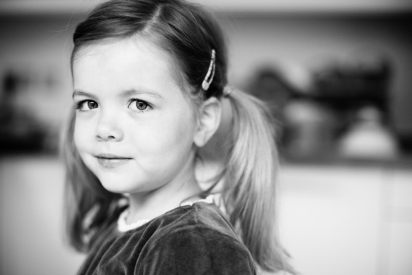 Girl with bunches smiles at camera.