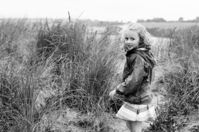 Girl walks through sand dunes.