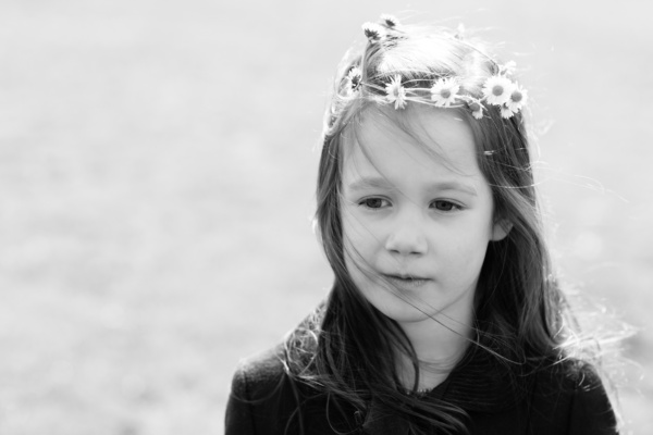 A girl wears a daisy crown.