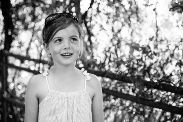 A girl's portrait with tree branches in the background.