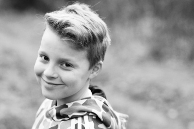 Headshot of smiling teenager outdoors.