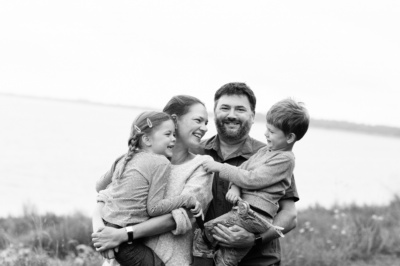 A London family hug together near the sea.