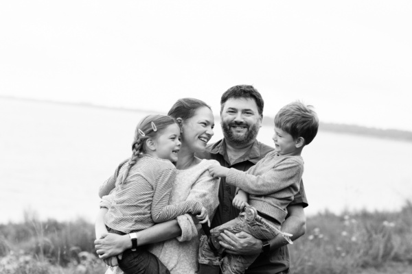 A London family hug together near the sea.