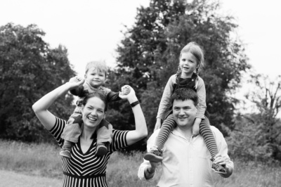 A London family portrait with children sitting on their parents' shoulders.