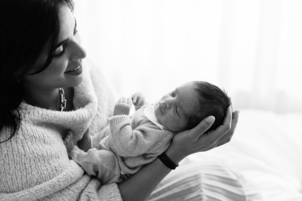 London mother holds sleeping newborn.