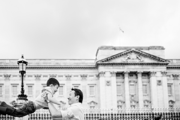 A father swings his son around outside Buckingham Palace, during a London family portrait shoot.