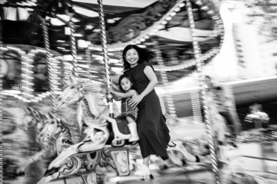 A mother and daughter on a merry-go-round horse during a London portrait shoot.