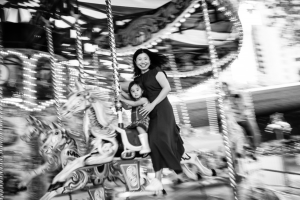 A mother and daughter on a merry-go-round horse during a London portrait shoot.