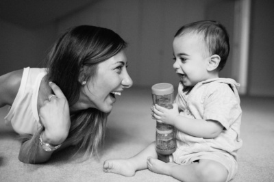 A mother and baby laugh together.