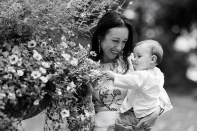 A mother and baby look at flowers together.