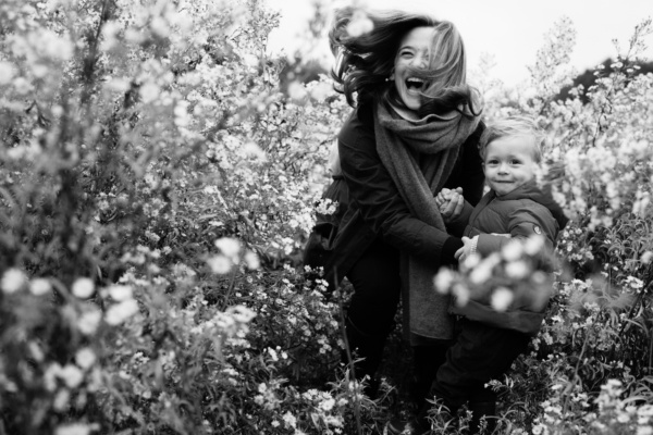 A mother and child play in flowers.