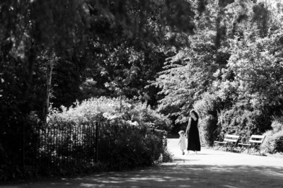 A mother and daughter walk through a park together in London.