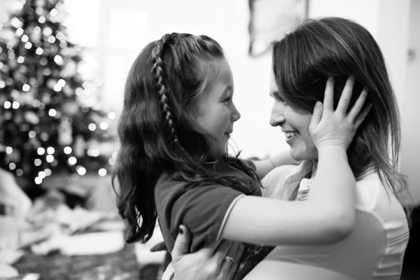 A mother and daughter hug each other.