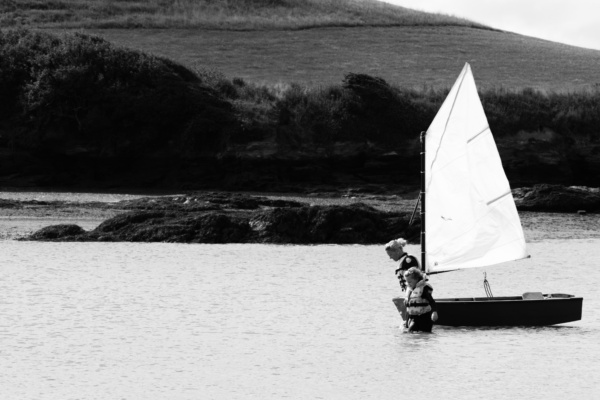 A mother and daughter walk a dinghy across the water.