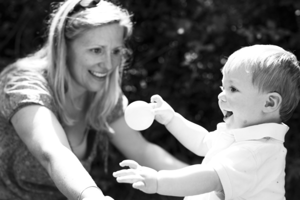 A mother and her son play in the garden.