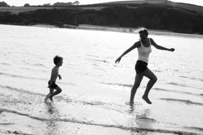 A mother and her son play in the waves.