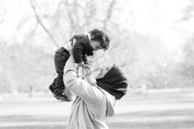 A mother holds up her toddler for a portrait while on holiday in London.