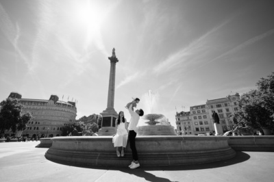 A portrait of parents and their toddler in Trafalgar Square, London.