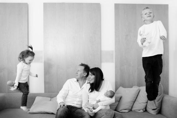 A newborn baby meets their older siblings in a family portrait shoot.