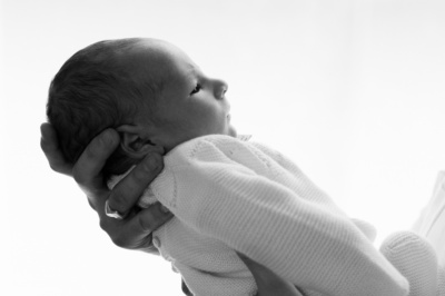 A parent holds their newborn's head.