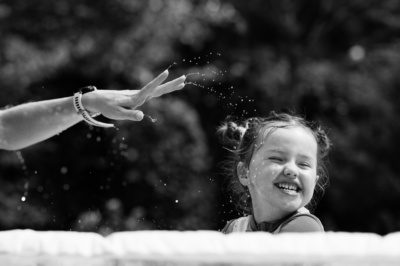 A parent flicks water at their child.