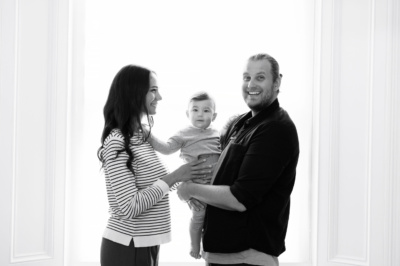 Parents and their baby in a black and white portrait.