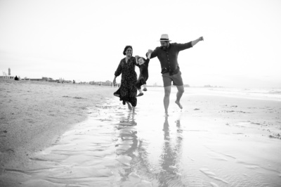 Parents and their child play at the beach.