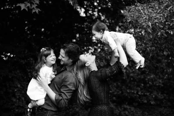 Parents lift their two children into the air.