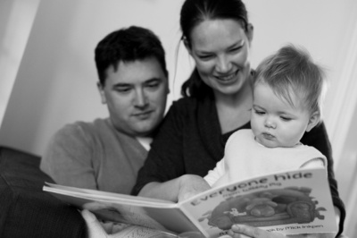 Parents read a book with their baby.