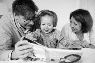 Parents read with their baby girl.