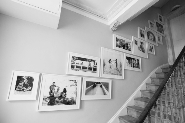 A photo gallery covers a wall alongside a staircase in a family home.