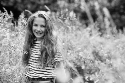 Portrait of a girl in a grassy field.