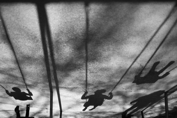 Shadows of children on swings.