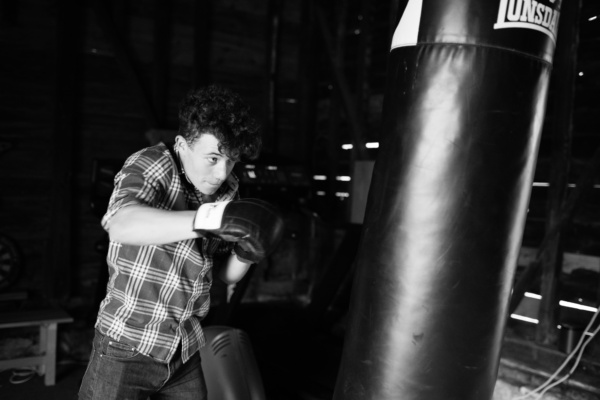 A teenager hits a punching bag during a family photo shoot.