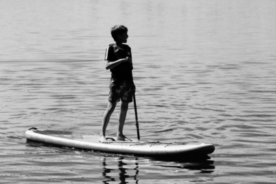 A teenager on an SUP paddles across the water.