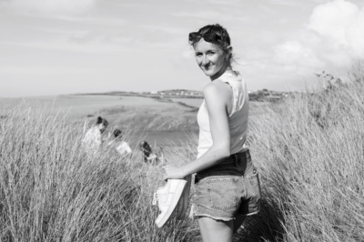 A teen walks through sand dunes.