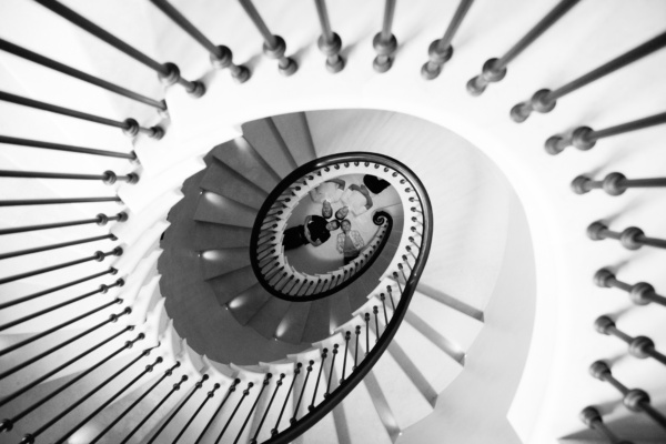 A family lies on the floor, framed by an oval staircase.