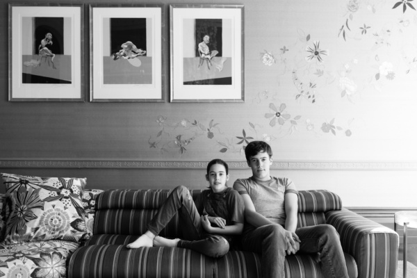 Black and white portrait of teenage siblings on a sofa.