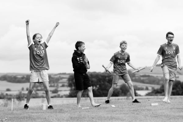 Teenage siblings play outdoor games on the lawn.