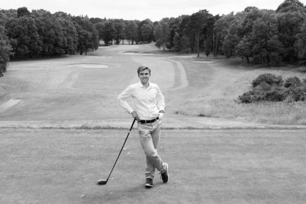 A teenager gets ready to tee off on a golf course.