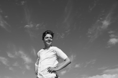 A teenager is photographed against the sky.