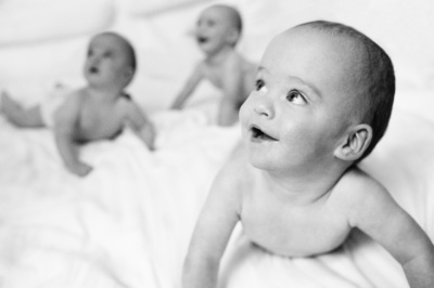 Three babies on a bed.